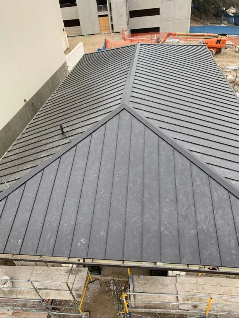 Commercial metal roof construction with crane equipment in Hull